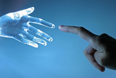 Showing an artificial hand touching a real human hand as relevance to the article about keeping in mind the customer experience while automating processes..